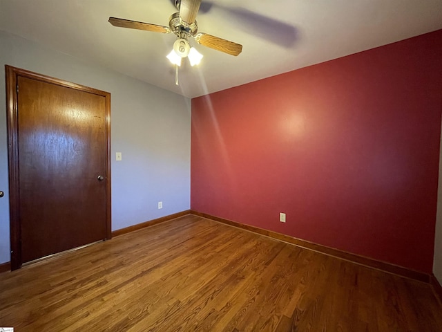 spare room with ceiling fan and wood-type flooring