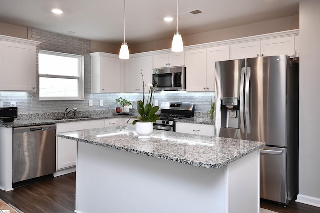 kitchen with white cabinetry, pendant lighting, a kitchen island, and stainless steel appliances