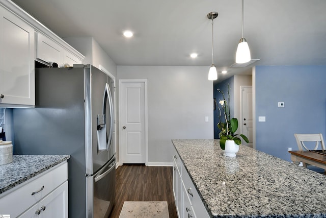 kitchen featuring white cabinets, decorative light fixtures, a kitchen island, and light stone countertops