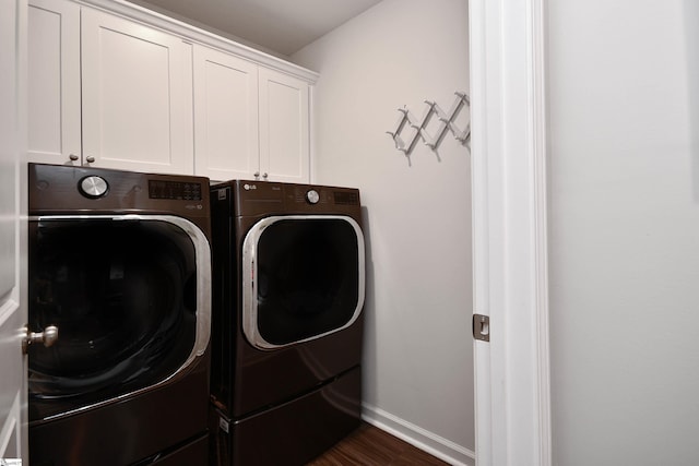 laundry area with cabinets, dark hardwood / wood-style flooring, and washer and clothes dryer