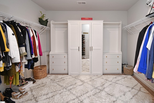 walk in closet featuring light carpet