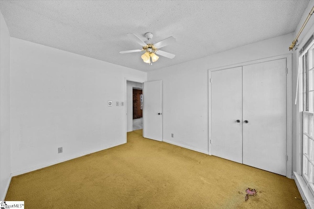 unfurnished bedroom featuring a textured ceiling, ceiling fan, light carpet, and a closet