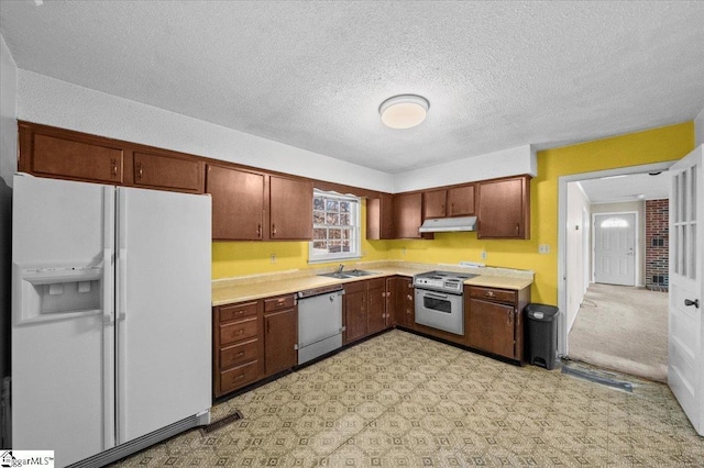 kitchen featuring wall oven, stainless steel range, sink, white refrigerator with ice dispenser, and dishwasher