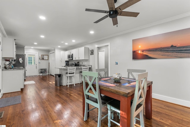 dining area featuring ceiling fan, ornamental molding, and dark wood-type flooring