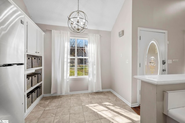 unfurnished dining area with light tile patterned floors, vaulted ceiling, and an inviting chandelier