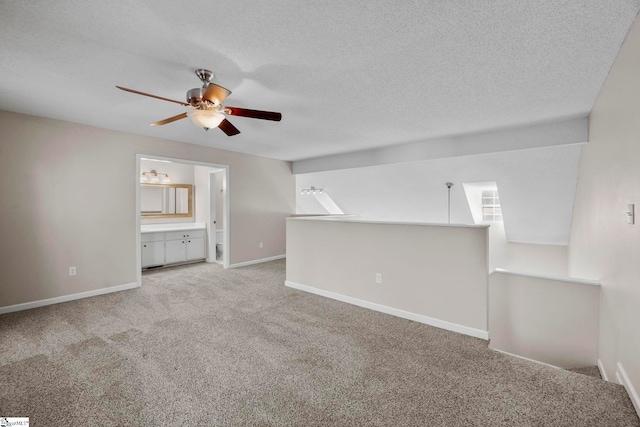 interior space featuring a textured ceiling, light colored carpet, and ceiling fan