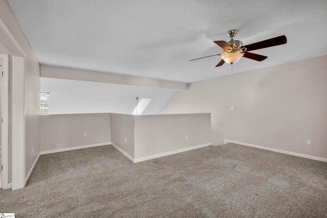 empty room with carpet, a textured ceiling, ceiling fan, and lofted ceiling