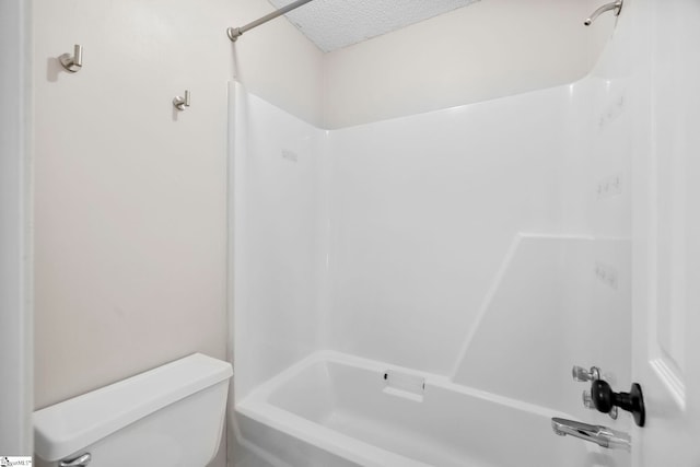 bathroom with bathtub / shower combination, a textured ceiling, and toilet