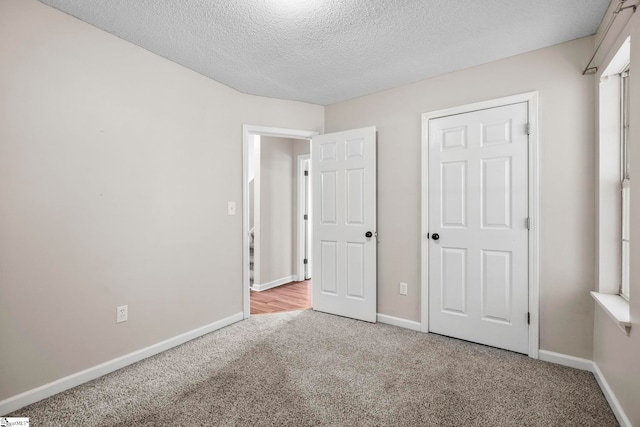 unfurnished bedroom with light carpet and a textured ceiling