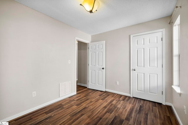 unfurnished bedroom with dark hardwood / wood-style flooring