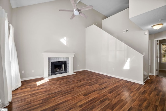 unfurnished living room with a fireplace, dark hardwood / wood-style floors, high vaulted ceiling, and ceiling fan