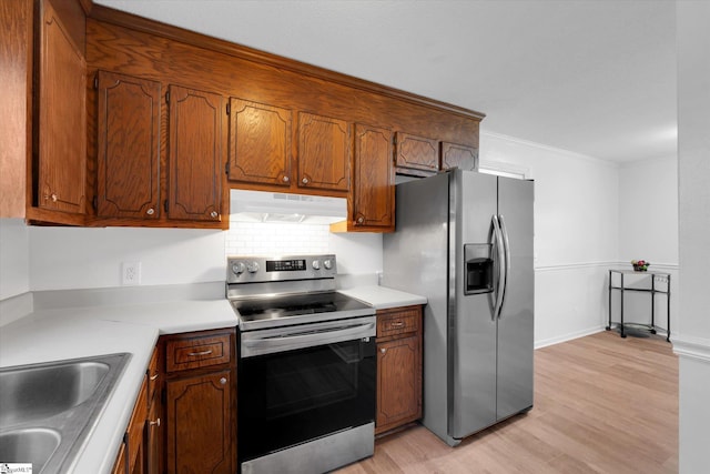 kitchen with light hardwood / wood-style floors, crown molding, sink, and appliances with stainless steel finishes