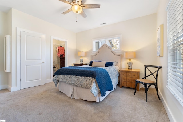 bedroom with ceiling fan, light colored carpet, a spacious closet, and a closet