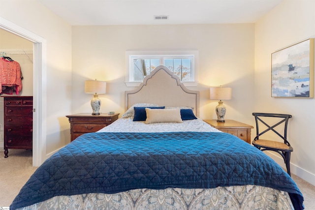 carpeted bedroom with a walk in closet and a closet