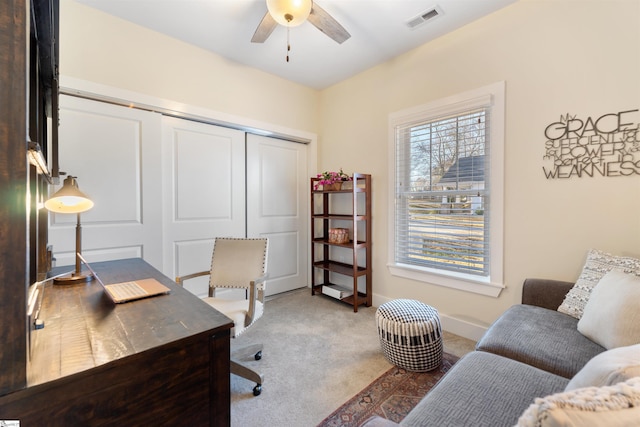 carpeted office space featuring ceiling fan