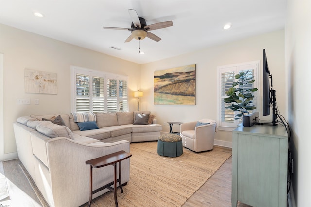 living room with ceiling fan, plenty of natural light, and light hardwood / wood-style flooring