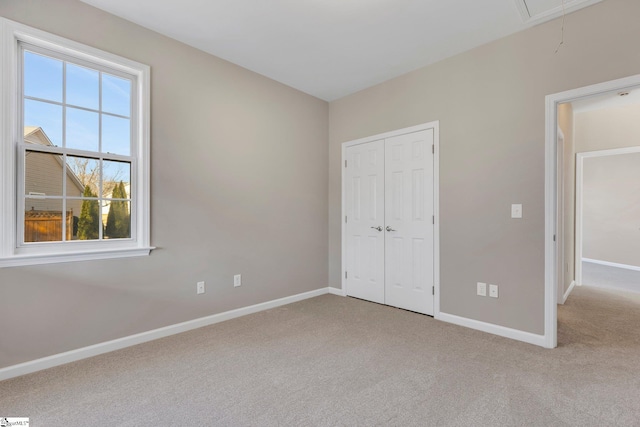 unfurnished bedroom with light carpet and a closet