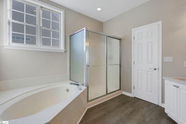 bathroom with vanity, plus walk in shower, and hardwood / wood-style flooring