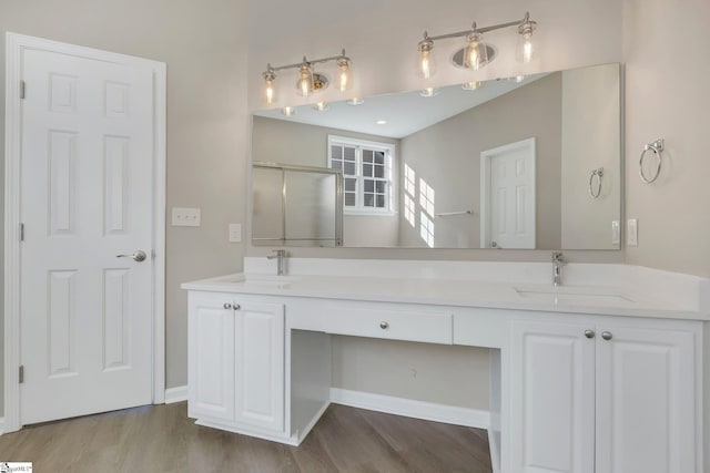 bathroom featuring hardwood / wood-style floors, vanity, and a shower with door