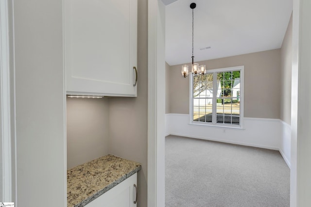 interior space featuring carpet floors and a chandelier