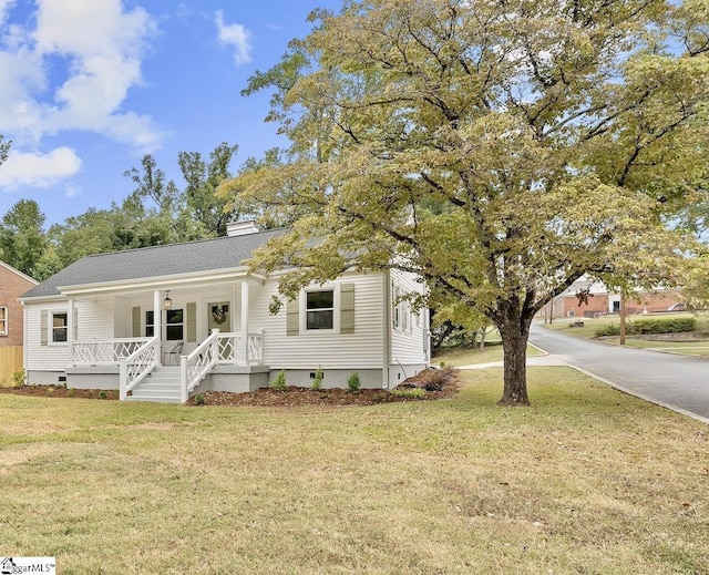 view of front of property with covered porch and a front lawn