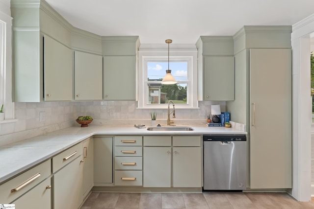 kitchen featuring sink, stainless steel dishwasher, backsplash, pendant lighting, and ornamental molding