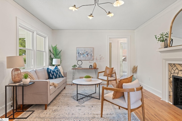 living room with a notable chandelier, crown molding, and light hardwood / wood-style flooring