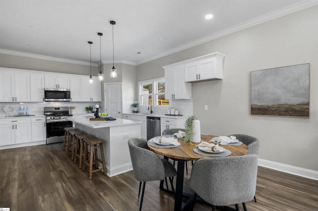 dining space with dark hardwood / wood-style flooring, ornamental molding, and sink