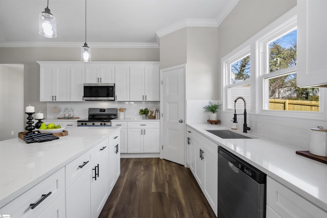 kitchen featuring pendant lighting, sink, decorative backsplash, appliances with stainless steel finishes, and white cabinetry