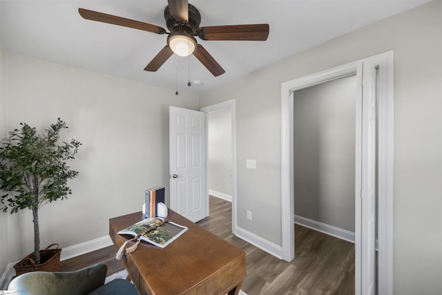 home office with dark hardwood / wood-style flooring and ceiling fan