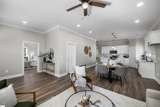 living room featuring crown molding, ceiling fan, dark wood-type flooring, and sink