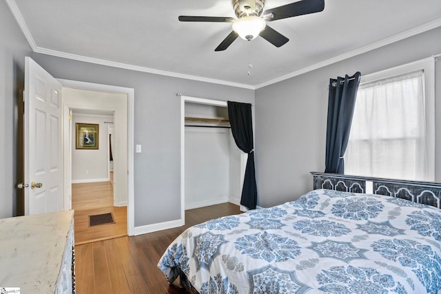 bedroom with ceiling fan, ornamental molding, dark wood-type flooring, and a closet