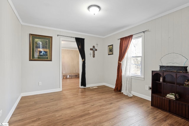 empty room featuring light hardwood / wood-style floors and crown molding