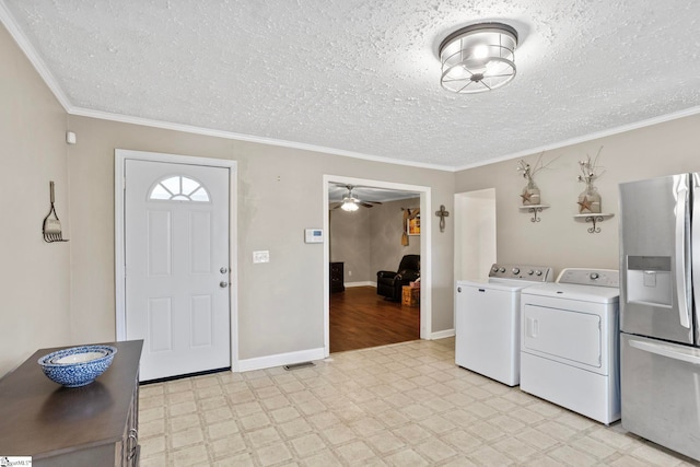 foyer entrance featuring a textured ceiling, ceiling fan, crown molding, and washing machine and clothes dryer