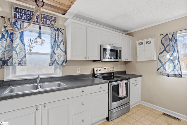 kitchen featuring white cabinets, appliances with stainless steel finishes, a textured ceiling, and sink