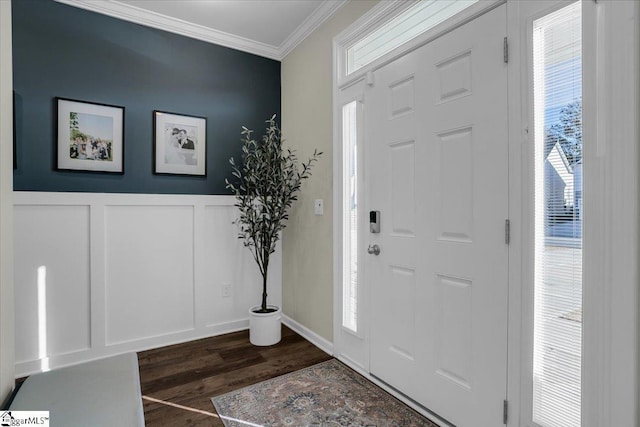 foyer with a healthy amount of sunlight, dark wood-type flooring, and ornamental molding