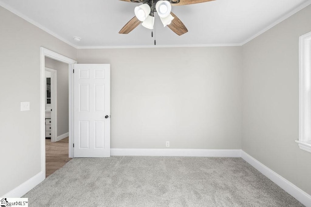 carpeted empty room featuring ceiling fan and ornamental molding