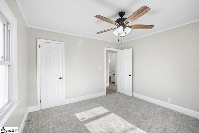 unfurnished bedroom featuring carpet flooring, a closet, ceiling fan, and crown molding