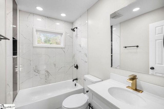 full bathroom featuring vanity, tiled shower / bath combo, and toilet