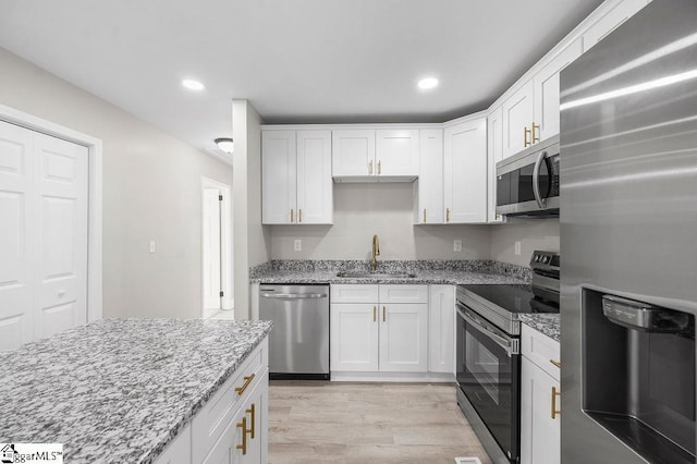 kitchen featuring light stone countertops, sink, white cabinets, and stainless steel appliances