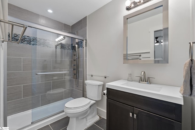 bathroom with tile patterned floors, vanity, an enclosed shower, and toilet