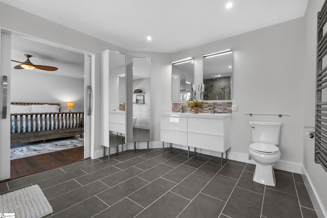 bathroom with tile patterned flooring, vanity, toilet, and ceiling fan