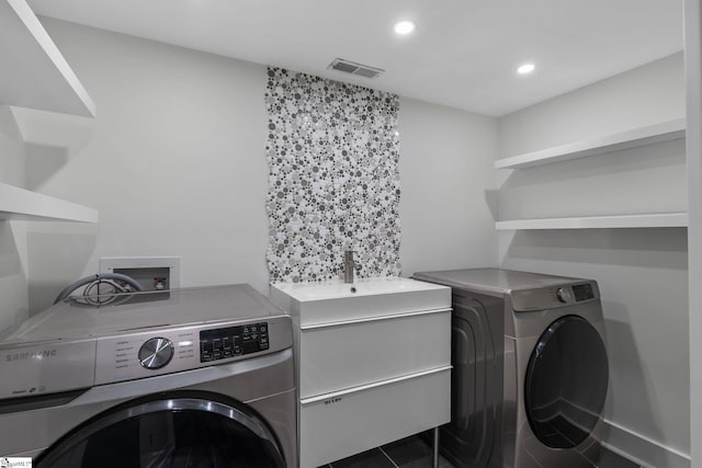 clothes washing area featuring dark tile patterned flooring and independent washer and dryer