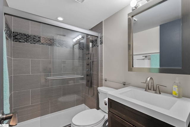 bathroom with vanity, an enclosed shower, and toilet