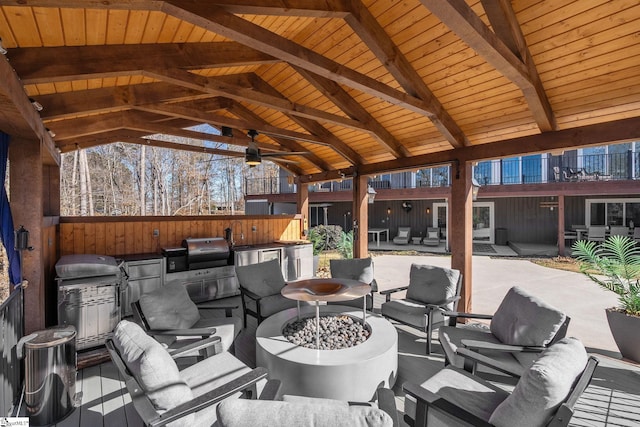 view of patio with a gazebo, an outdoor kitchen, a grill, and an outdoor living space with a fire pit