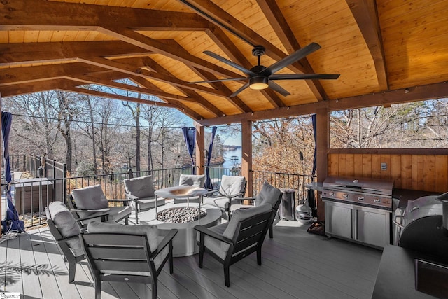 wooden deck with ceiling fan, area for grilling, exterior kitchen, and an outdoor living space with a fire pit