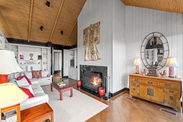 living room featuring high vaulted ceiling, built in features, wooden ceiling, and light wood-type flooring