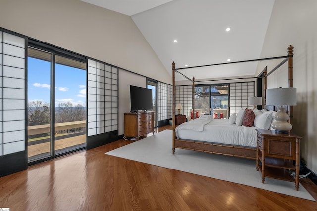 bedroom with wood-type flooring, high vaulted ceiling, and multiple windows