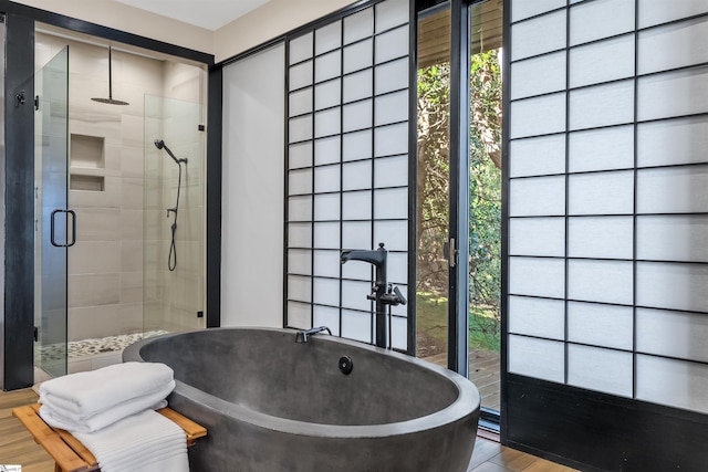 bathroom with plenty of natural light, plus walk in shower, and wood-type flooring