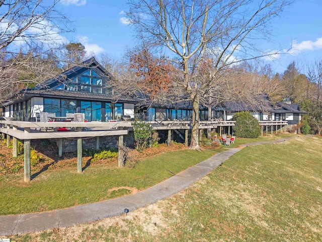 back of house with a wooden deck and a yard